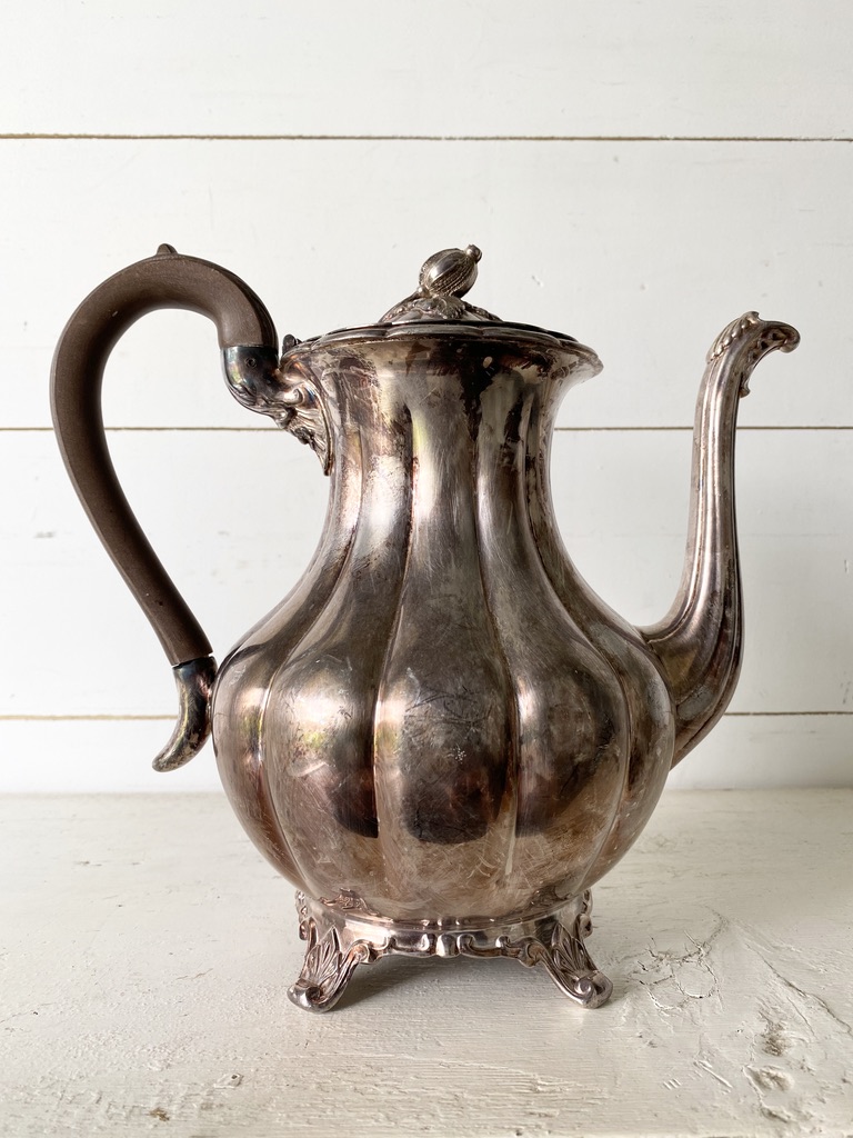A vintage silver teapot with a warm patina perfect for fall decor