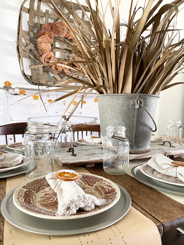 A dried palm frond centerpiece for a Thanksgiving tablescape