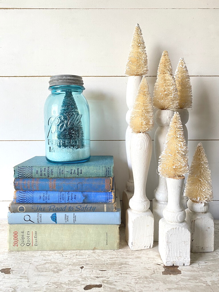 Bottle brush trees atop spindles and in a mason jar as winter decor
