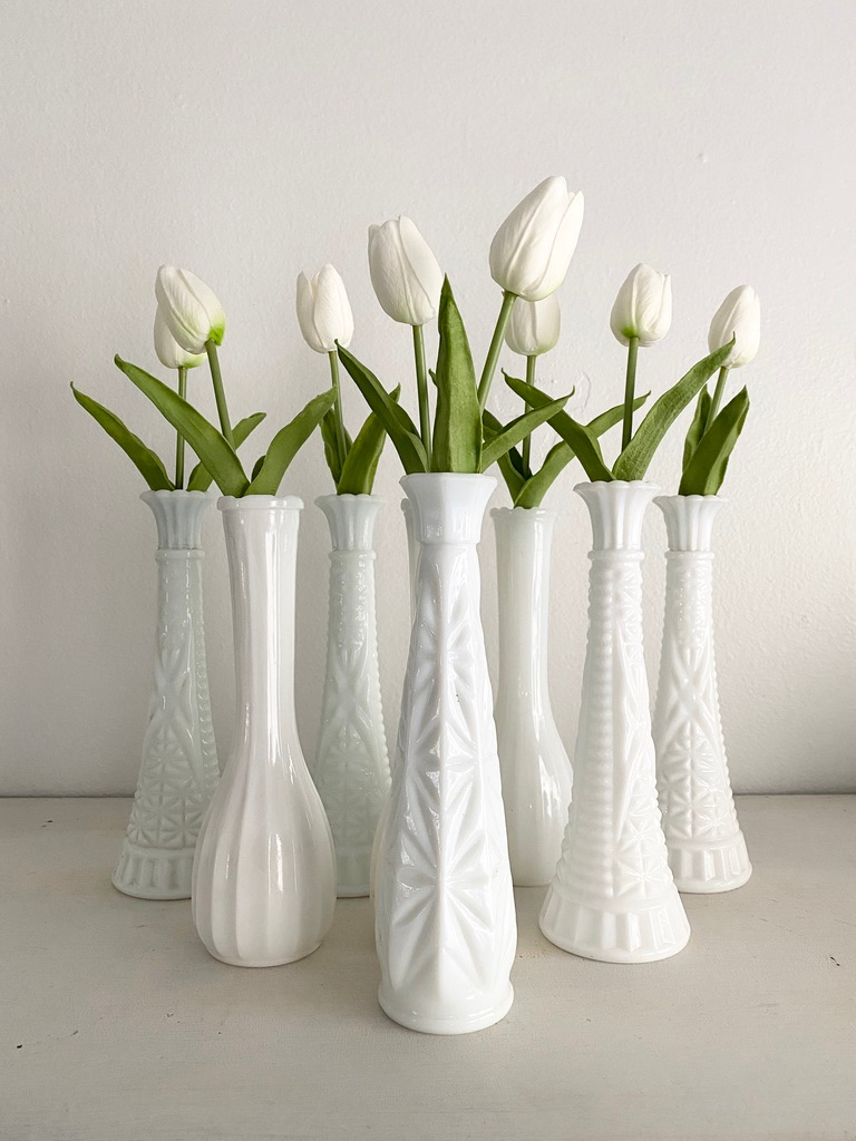Milk glass bud vases filled with white tulips
